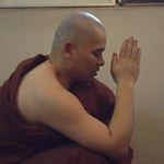 Wearing the monastic robe, the future monk join respectfully the hands